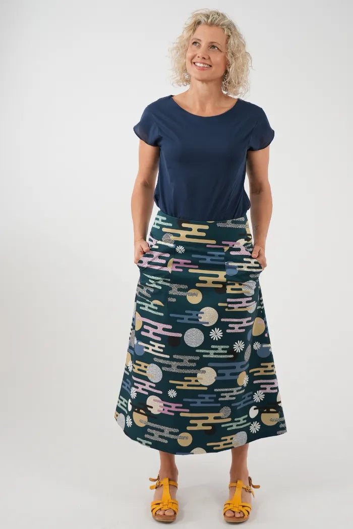 A woman modeling a navy blue short-sleeve top and a dark teal midi skirt 